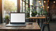 © Chatchanan - Blank screen laptop mockup on a rustic wooden table in a stylish coffee shop, ideal for showcasing your ad content.