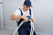 © Studio Peace - Construction worker in uniform cuts a PVC pipe during renovation in an apartment.