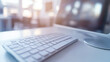 © Chatchanan - White computer keyboard in a blurred office background, suggesting a sleek and efficient work setting.