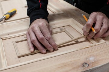 Bespoke joinery showing the carpenter doing all the tasks using the tools like hammer, chisel, drill, steel ruler, glue gun and pencil