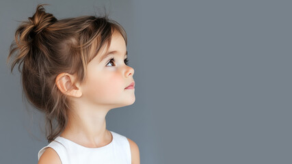 Wall Mural - Side view of Canadian little girl wearing white dress isolated on gray