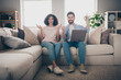 © deagreez - Photo of two people sit couch have netbook raise fists up winning in apartment house indoors