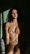 © TeteraX - Young woman in floral bikini poses in soft light, creating dramatic shadows in a cozy room