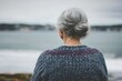 © volga - Serene elderly woman gazing at sea shore
