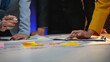 © amnaj - Business team working late in the office analyzing financial data and developing a strategy