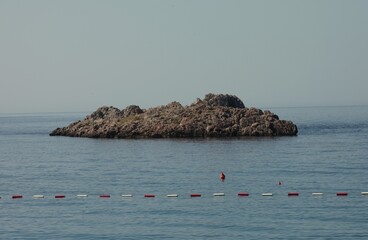 A stone rock like an island in the middle of the sea