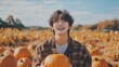 © BackgroundHolic - Young happy pretty Kpop idol boy picking pumpkins at pumpkin patch, Asian young man celebrating Thanksgiving Halloween in harvest autumn season.