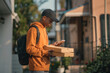 © Nomad_Soul - Delivery man checking phone with pizza boxes in hand, residential street. Generative AI