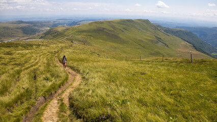 Wall Mural - jeune fille sur une sentier de randonnée gravissant le Plomb du Cantal, sommet volcanique d'Auvergne en France en été