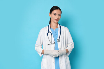 Wall Mural - Beautiful nurse in uniform on light blue background