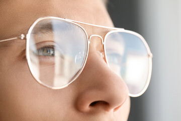 Vision correction. Man wearing glasses on blurred background, closeup