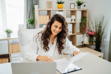 Wall Mural - Young caucasian business woman working in office on laptop