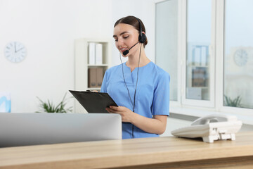 Sticker - Professional receptionist working at wooden desk in hospital