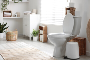 Wall Mural - White toilet bowl, trash can and paper rolls in bathroom