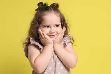 Portrait of cute girl on yellow background. Adorable child