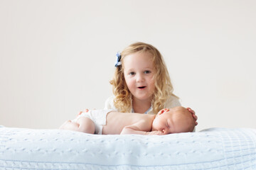 Wall Mural - Child watching newborn baby in bassinet.