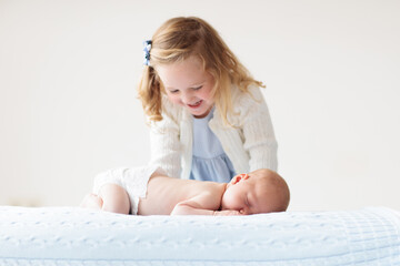 Wall Mural - Child watching newborn baby in bassinet.