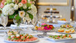 © Luluraschi - Catered event setup with elegant table settings, appetizers, and floral arrangements