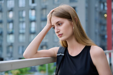 Upset sad unhappy young female outdoor urban style background