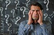 © Ilja - Overwhelmed Man Grimacing with Hands on Head, Surrounded by Question Marks on Blackboard