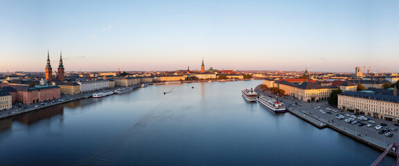 Wall Mural - Waterfront Cityscape with Historic Architecture and Twin Church Towers at Sunset