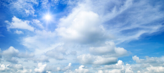 Wall Mural - Blue sky with clouds and bright sun. Wide photo.