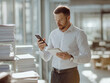 © Studio Aurelia - handsome business man using a smartphone and looking at files