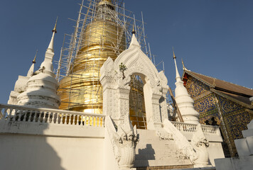 Wall Mural - Whitewashed chedi of Wat Suan Dok covered with bamboo scaffolding in Chiang Mai, Thailand