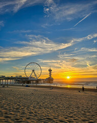 Wall Mural - Sunset sky at scheveningen beach with pear and ferris wheel in the background 