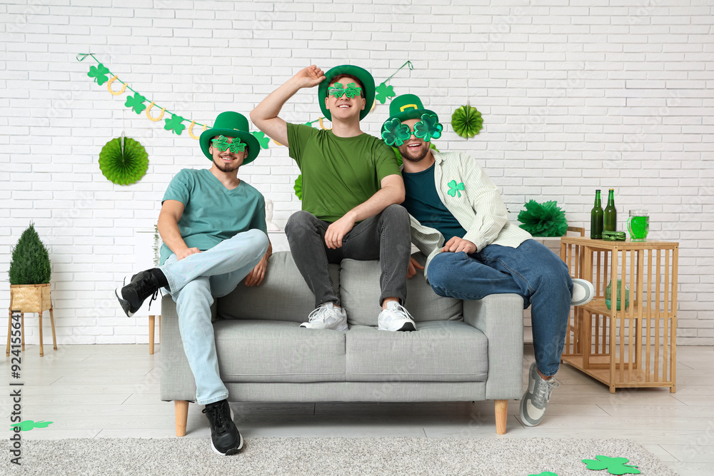 Happy young men with party glasses at home. St. Patrick's Day celebration