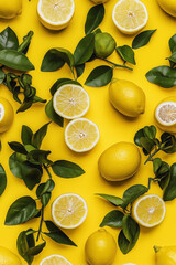 Poster - A seamless pattern of lemons and green leaves against a bright yellow background. The fresh, vibrant design features whole and sliced lemons, creating a zesty, summery feel.