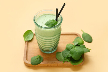 Wall Mural - Glass of fresh spinach smoothie on yellow background