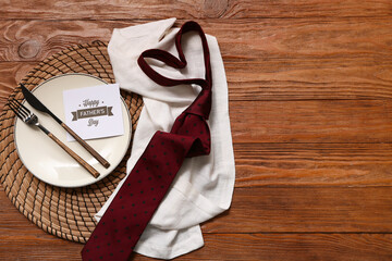 Wall Mural - Festive decorated table setting with greeting card and tie on brown wooden background. Father day celebration concept