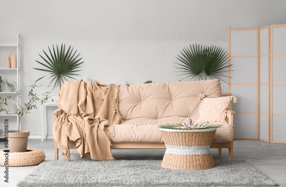 Soft sofa with plaid and coffee table in interior of living room