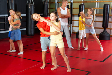 Wall Mural - Kids in pairs training elbow strike during their self-protection training.