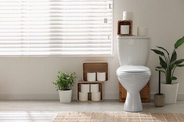 Poster - White toilet bowl, paper rolls and houseplants in bathroom