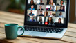 © Astock Media - A blue mug sits in front of a laptop with a video conference on the screen.