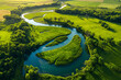 © Henry Saint John - Winding river through lush green landscape captured from above.
