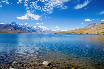 A tranquil lake surrounded by majestic mountains and clear blue skies, perfect for nature lovers and landscape photography.