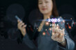 © DG PhotoStock - Businesswoman touching on virtual holographic or hologram buttons showing trends in 2025.