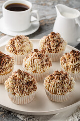 Wall Mural - Soft espresso cupcakes soaked in coffee, and topped with mascarpone cream closeup on the plate on the table. Vertical