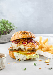 Wall Mural - Juicy Burger with Patty, Two Sauces, and Fries on a Rustic Table