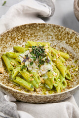 Wall Mural - Delicious Penne Pasta with Stracciatella and Pesto Sauce Close-Up of a Tasty Dish