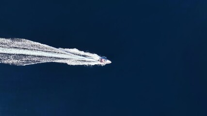 Wall Mural - high aerial overhead view of a rib boat crossing the blue ocean with speed