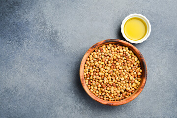 Wall Mural - Soybean oil. A bowl of soybeans and oil in a saucepan. On a stone background