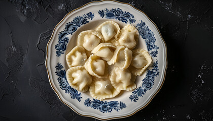 Plate of traditional russian pelmeni, ravioli or dumplings on black background, top view