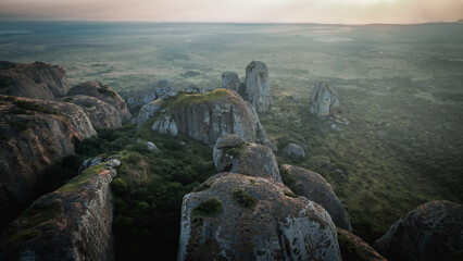 Sunset over the rugged Pedras Negras Mountains in Angola, showcasing unique rock formations and lush vegetation