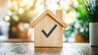 © Mahmud - A visual featuring a wooden house model placed on a desk with a check mark symbol. This image represents home inspections, adherence to standards, and certifications for real estate safety.