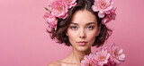 Close-up portrait of a woman with pink flowers, set against a matching pink background, embodying beauty and femininity.