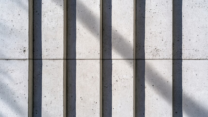 Canvas Print - A close up of the textured concrete facade of a brutalist structure with shadows emphasizing the raw rugged surface 